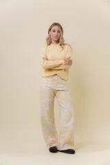 Pantalón de jean de pierna ancha y tiro medio-alto, con estampado suave en tonos amarillos y blancos.