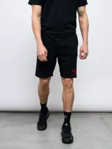Bermuda deportiva negra de felpa con logo de Umbro bordado en rojo en la pierna derecha.