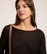 Suéter negro de punto con cuello redondo y mangas largas.