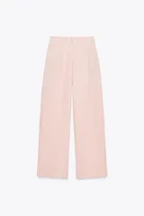 Pantalón de vestir color rosa pálido, de tiro alto, con pinzas delanteras, bolsillos laterales, pierna ancha y cierre frontal con cremallera y botón.