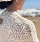 Poncho tejido en hilo de algodón con lurex color negro y dorado, con flecos en el ruedo.