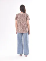 Remera blanca con estampado abstracto en tonos rosa, lila, azul y negro.