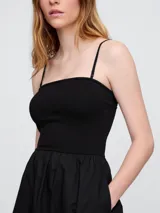 Vestido midi strapless color negro, con elástico en el busto y falda amplia.