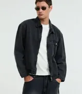 Campera de jean azul oscuro, corte boxy, con cuello inglés, cierre frontal con cremallera, manga larga y bolsillo con cierre en el pecho.