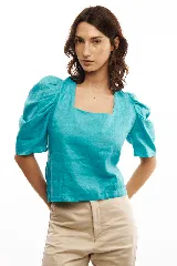 Blusa celeste de lino con escote cuadrado, mangas abullonadas y lazo en la espalda.