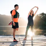Remera deportiva naranja de poliéster, con mangas cortas y logo de la marca Merrell estampado en el pecho.