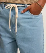 Pantalón de jean celeste, corte baggy relaxed, con cintura con trabillas y cordón ajustable.