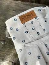 Pantalón de campo color crudo con estampado de pequeñas flores azules, de lino artesanal.