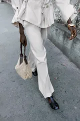 Pantalón ancho color beige de tiro alto con cintura elástica y bolsillos delanteros.