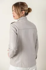 Campera roja de cuero ovino italiano, con charreteras en los hombros, bolsillos laterales, broches ocultos en el frente y broches a la vista en cuello y puños.
