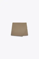 Falda pantalón color beige de tiro medio con diseño asimétrico.