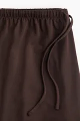 Pantalón marrón de corte holgado en punto suave, con piernas rectas y elástico revestido con cordón para ajustar en la cintura.