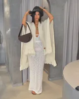 Vestido largo de tejido de punto color crema, con escote halter y aberturas laterales.