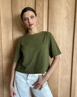 Remera negra con cuello redondo y mangas cortas, con detalle de pespuntes blancos en cuello, mangas, bolsillos frontales y ruedo.