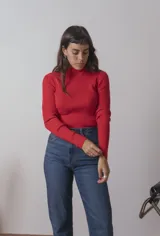 Polera roja de tejido de punto acanalado, con cuello alto y mangas largas.