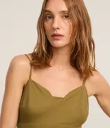 Mono largo color verde oliva, de breteles finos y escote corazón. Presenta recortes en el busto y la cintura, además de pliegues.