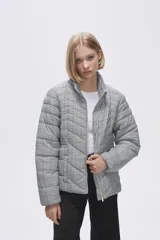 Campera puffer corta con cuello alto y cierre frontal, con estampado a cuadros en tonos grises, blancos y negros.