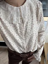 Camisa color crema con estampado de hojas en color vino, cuello babero y puños con puntilla de tul bordado en algodón.