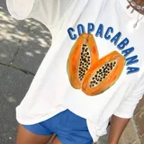 Remera blanca de manga larga con estampado de dos papayas cortadas y la palabra 'Copacabana' en azul.