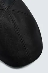 Boina negra con visera confeccionada en tejido con algodón y lino.