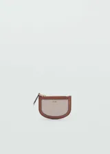 Monedero pequeño de tela color beige con borde de cuero marrón, cierre de cremallera y logo MNG dorado en el frente.