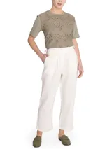 Pantalón de lino color verde, de tiro alto y pierna recta, con cierre cruzado y hebillas en los costados.