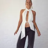 Top blanco con textura, cuello halter y abertura en el frente.
