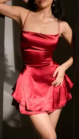 Vestido corto de satén rojo con breteles finos y falda con volados.