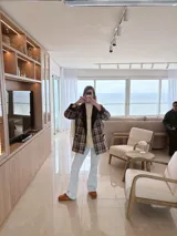 Blazer marrón con estampado escocés, solapas con borde de terciopelo marrón oscuro y corte recto.