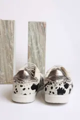 Zapatillas deportivas bajas con estampado animal print de vaca en blanco y marrón.