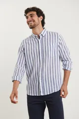 Camisa de lino a rayas verticales azules y blancas, de manga larga con puños abotonados y cuello clásico.