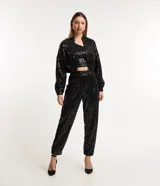 Pantalón jogger de lentejuelas negras con cintura elástica y puños ajustados.