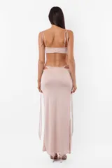 Conjunto de top y falda larga confeccionado en tela con brillos color gris. El top cuenta con arco metálico en el busto, tiras finas para atar en el hombro y ganchos lenceros en la espalda. La falda tiene tiras largas para atar de forma que queden a la vista.