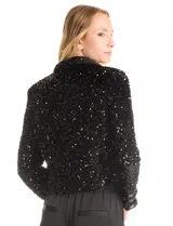 Chaqueta corta negra de lentejuelas con solapa y cuello abierto.