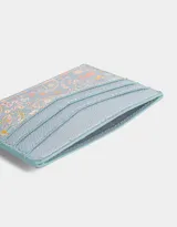 Tarjetero color celeste con estampado floral y tres ranuras para tarjetas.