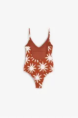 Traje de baño enterizo color terracota con estampado de soles blancos, escote en V, espalda abierta, tirantes regulables y copas removibles.