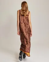 Vestido largo sin mangas con escote redondo y estampado geométrico en tonos marrones, naranjas y blancos.