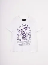 Remera blanca de manga corta con cuello redondo y estampado frontal en color violeta con motivos florales y texto en francés.