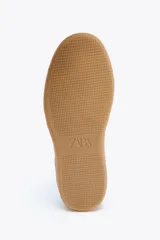 Zapatillas deportivas celestes con detalles en blanco y amarillo.