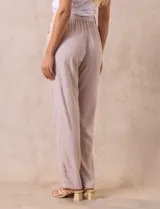 Pantalón de lino color amarillo con pretina ancha, pasadores y lazo de ajuste.
