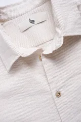 Camisa de manga larga con corte regular en tejido de algodón a rayas, con botones de madera y parche con logo.