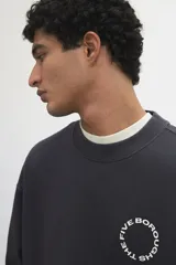 Buzo de algodón pesado color gris oscuro con efecto lavado e interior cepillado suave. Modelo con diseño estampado circular en el pecho, cuello redondo y hombros caídos. Remate acanalado en cuello, puños y bajo. Corte holgado.