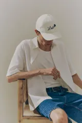 Camisa de manga corta color crema, de corte holgado, con cuello inglés, tapeta lisa, canesú en la espalda y bajo recto. Confeccionada en mezcla liviana de lino y viscosa.