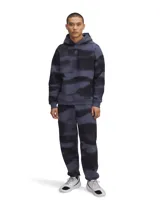 Pantalón de jogging gris con estampado abstracto en negro, con puños elásticos y logo bordado en la pierna izquierda.