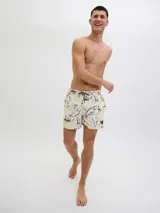 Short de baño color crema con estampado de flores y hojas en blanco, negro y amarillo. Tiene cintura elástica con cordón ajustable, bolsillos laterales y un bolsillo trasero.