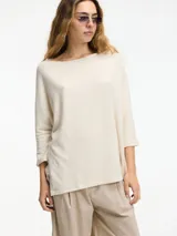Sweater color crema de mangas 3/4, fit amplio y largo más largo en la parte trasera.