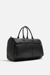 Bolso de viaje negro con textura grabada, compartimento principal con cierre de cremallera, bolsillo interior con cremallera, bolsillo frontal con cremallera, asa de hombro removible y ajustable.