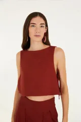 Top corto color ladrillo, sin mangas, con escote redondo y lazos laterales ajustables.