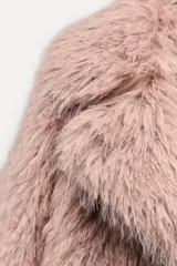 Abrigo de pelo sintético color rosa pálido, con cuello solapa, manga larga y cierre frontal con botones ocultos.