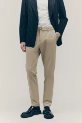 Pantalón chino color beige, de corte slim fit, con bolsillos laterales y traseros.